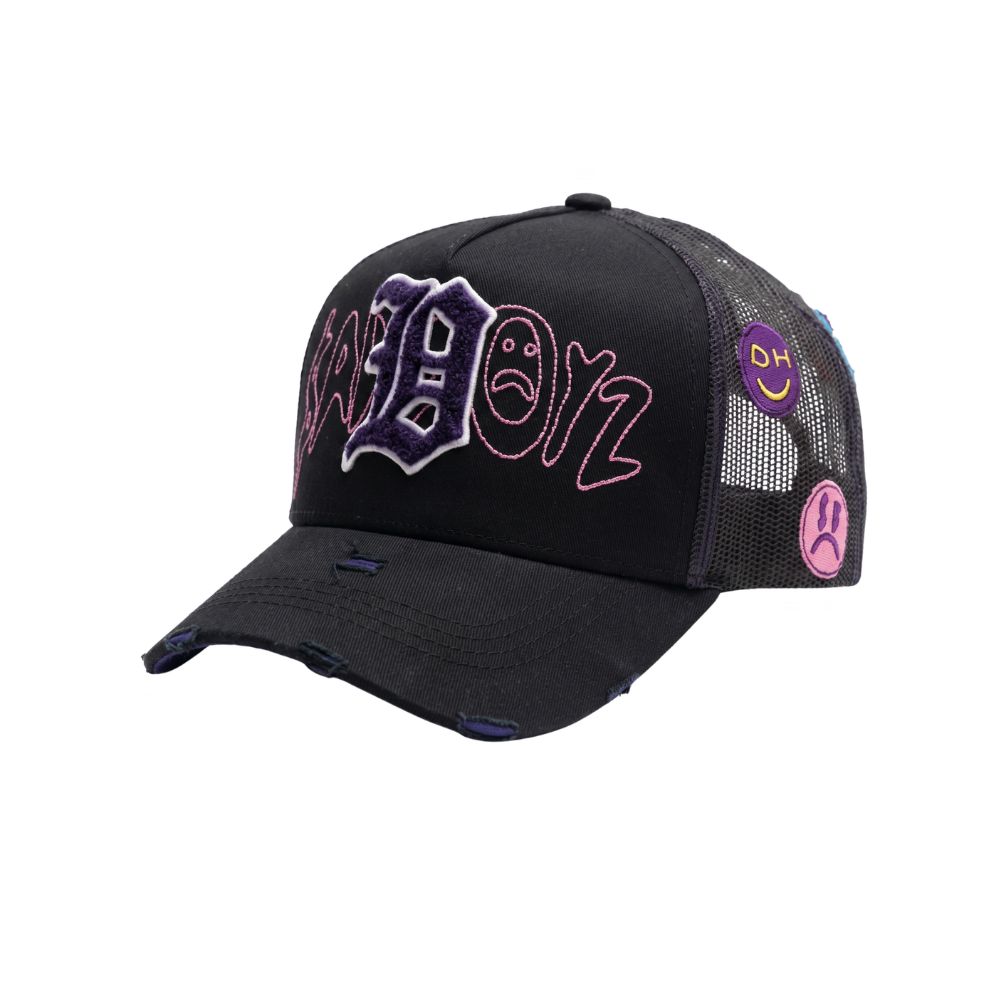 Gorra Extssy Model negra con letra bordada morada en relieve, detalles rosas y parches laterales