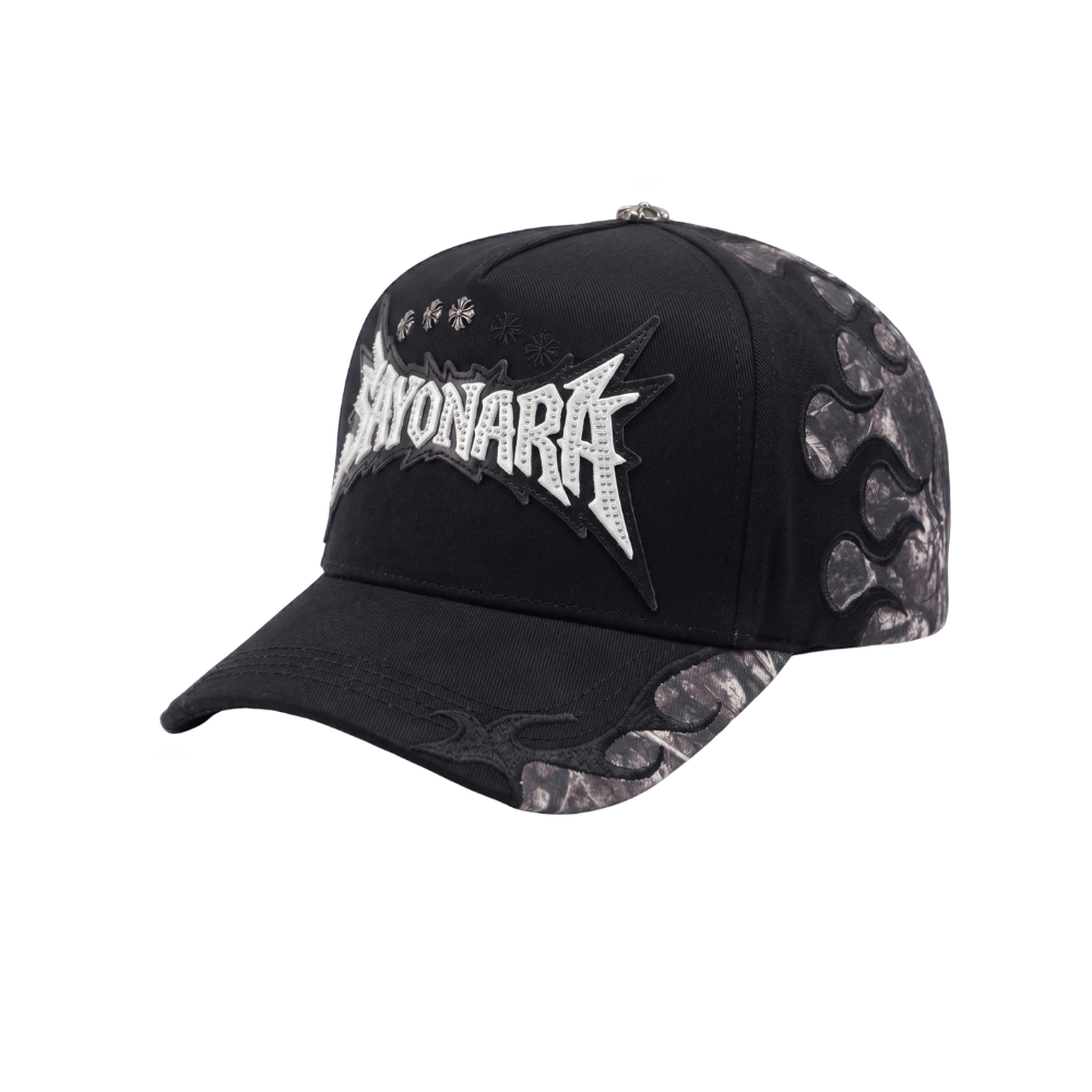Gorra Sayonara negra con bordado frontal blanco, paneles laterales grises y detalles metálicos