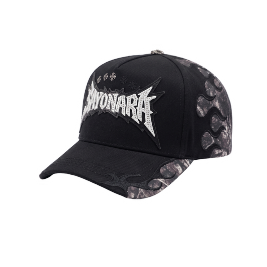 Gorra Sayonara negra con bordado frontal blanco, paneles laterales grises y detalles metálicos