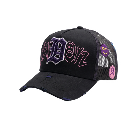 Gorra Extssy Model negra con letra bordada morada en relieve, detalles rosas y parches laterales
