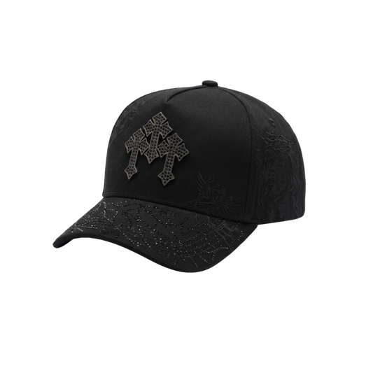 Gorra Cristo Chrome negra con cruces oscuras al frente, detalles grabados religiosos y visera con diseño bordado en negro