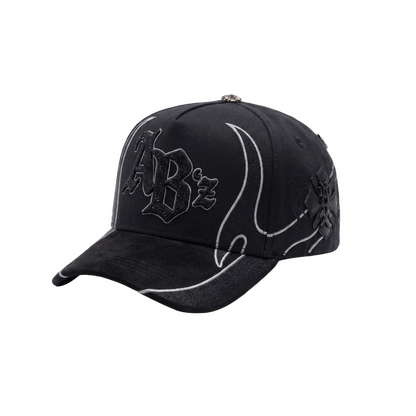Gorra AB’z Total Black negra con bordado frontal y piedrería negra brillante, líneas curvas en contraste y detalles laterales oscuros