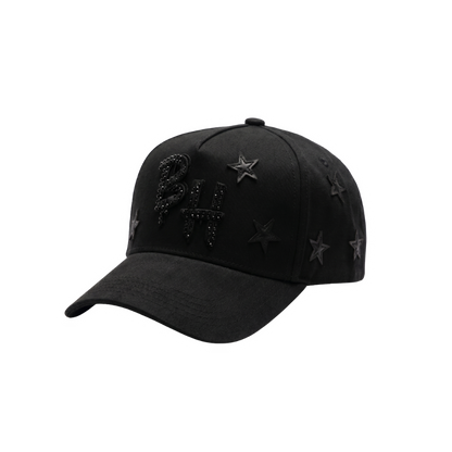 Gorra Blackout Stars negra con logo frontal en negro, detalles de piedrería oscura y estrellas laterales sobre acabado total black