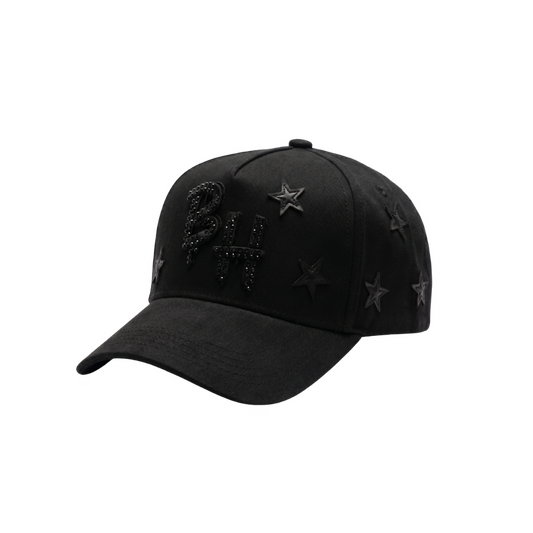 Gorra Blackout Stars negra con logo frontal en negro, detalles de piedrería oscura y estrellas laterales sobre acabado total black
