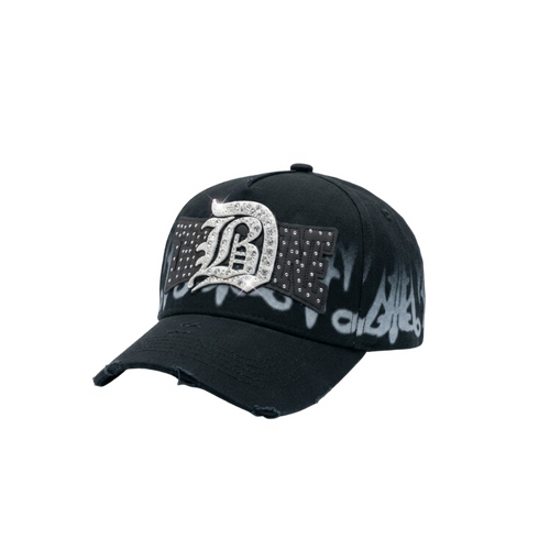 Gorra DB31 negra con logo frontal brillante tipo pedrería, detalles en contraste y efecto gráfico difuminado en blanco sobre la base