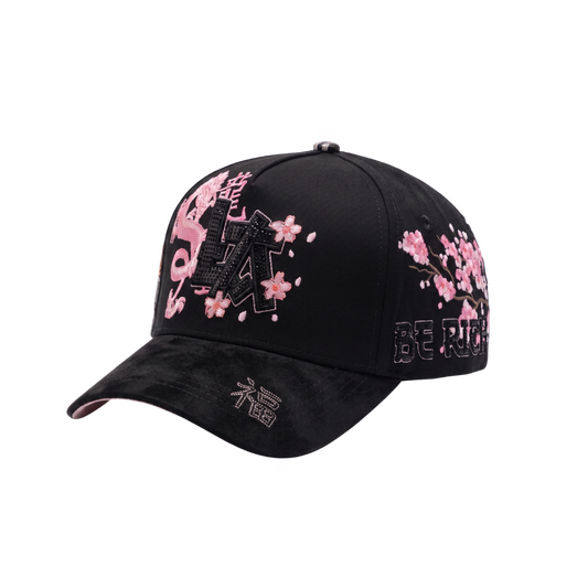 Gorra LA Japan 2.0 negra con aplique frontal LA negro, dragon y flores rosadas, grafico lateral de gato japones y visera curva negra.