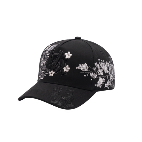 Gorra LA Japan negra con aplique frontal LA negro, dragon y flores blancas al frente, graficos laterales oscuros con detalles rojos y visera curva negra.