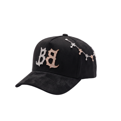 Gorra Inferno negra con bordado frontal BB en pedreria plateada y rose gold, cadena lateral de cruces brillantes y visera negra texturizada